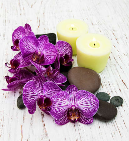 Candles, orchids and massage stones on a wooden backgroundの写真素材