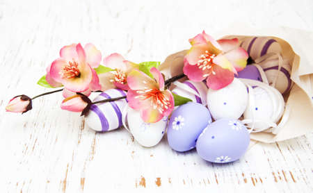 Easter eggs with flowers package of paper on a old wooden backgroundの写真素材