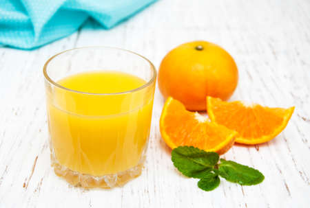 Orange juice with fresh fruits on a wooden backgroundの写真素材