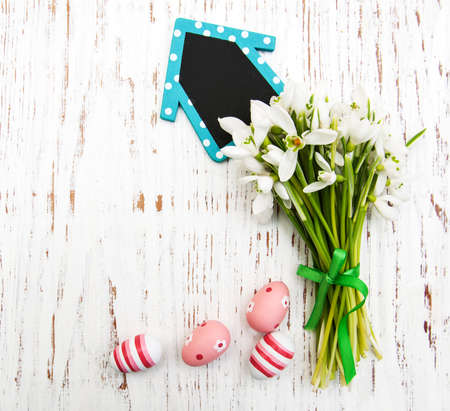 Eggs and spring snowdrops with board on a wooden backgroundの写真素材