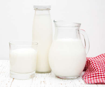 Jar, bottle and glass with fresh milk on a wooden backgroundの写真素材