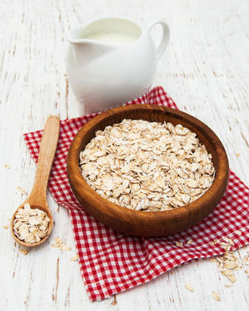 bowl of oat flake and milk on a wooden backgroundの写真素材