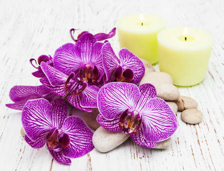 Candles, orchids and massage stones on a wooden backgroundの写真素材