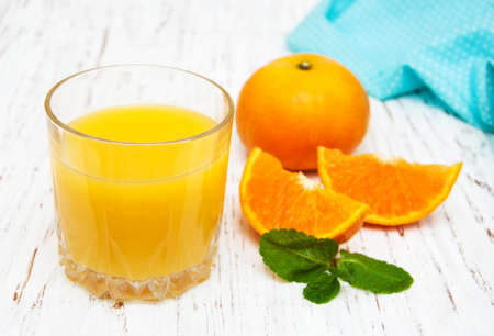 Orange juice with fresh fruits on a wooden backgroundの写真素材