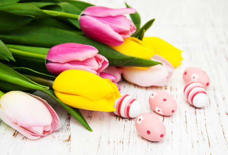 Tulips and easter eggs on a old wooden backgroundの写真素材