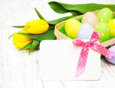 card with fresh flowers tulips and easter eggsの写真素材
