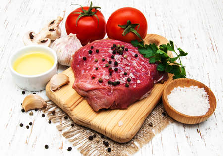 fillet of beef and ingredients on a old wooden backgroundの写真素材