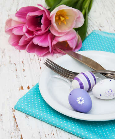 Easter table setting with easter eggs and pink tulips
