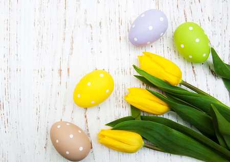 Tulips and easter eggs on a old wooden background