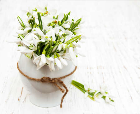 Spring snowdrops in a vase  on a old wooden backgroundの写真素材
