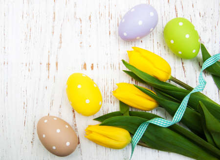 fresh flowers tulips and easter eggs on a wooden backgroundの写真素材