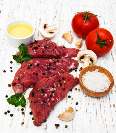 fillet of beef and ingredients on a old wooden backgroundの写真素材