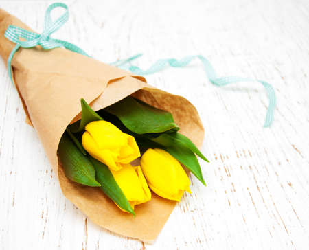 Yellow tulips  on a old wooden backgroundの写真素材