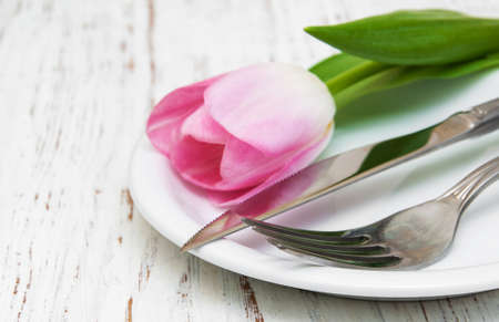 pink tulip in a plate on a old white wooden backgroundの写真素材