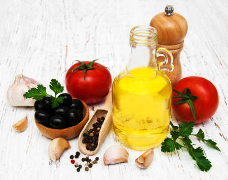 Olive oil, garlic, tomato and pepper on a old wooden backgroundの写真素材