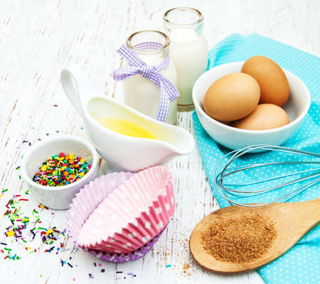 ingredients needed for baking cupcakes on a old wooden backgroundの写真素材