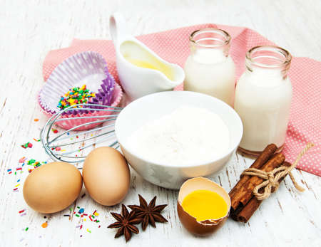 ingredients needed for baking cupcakes on a old wooden backgroundの写真素材