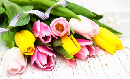 Tulips and gift box on a old wooden backgroundの写真素材