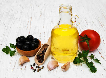 Olive oil, garlic, tomato and pepper on a old wooden backgroundの写真素材