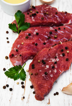 fillet of beef and ingredients on a old wooden backgroundの写真素材