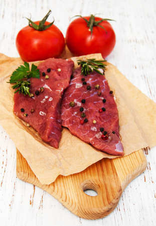 fillet of beef and ingredients on a old wooden background