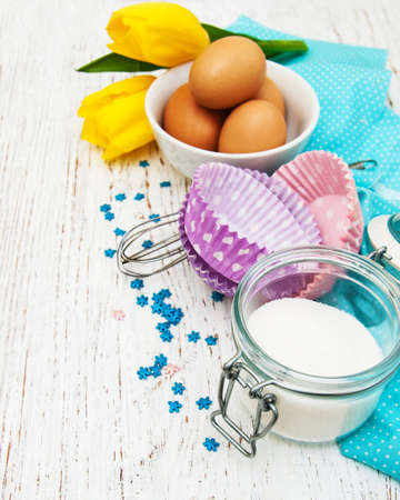 Eggs, sugar for preparing muffins on a wooden backgroundの写真素材