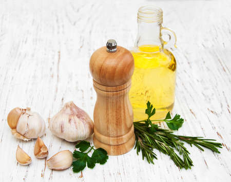 olive oil, rosemary and garlic on a old wooden backgroundの写真素材