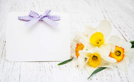 daffodil flowers with card on a wooden backgroundの写真素材