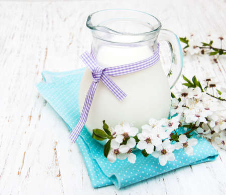 Milk and spring blossom on a old wooden backgroundの写真素材