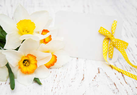 daffodil flowers with card on a wooden backgroundの写真素材