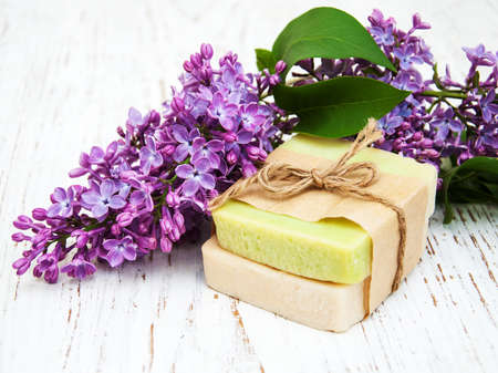 Natural handmade soap and lilac flowers on a wooden backgroundの写真素材