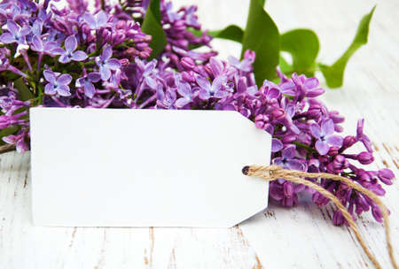 Lilac flowers with empty tag on a old wooden backgroundの写真素材