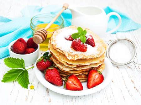 Pancakes with strawberries on a wooden backgroundの写真素材