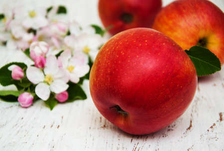 apples and apple tree blossoms on a wooden backgroundの写真素材