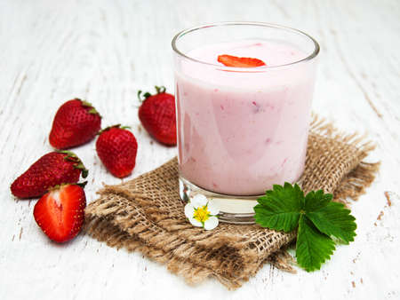 Strawberry yogurt with fresh strawberries on a wooden backgroundの写真素材