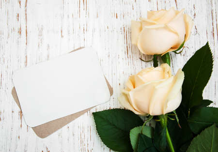 Roses with a card on a old wooden backgroundの写真素材