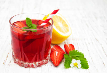 Glass with strawberry drink on a wooden backgroundの写真素材