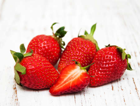Strawberries with leaves on a wooden backgroundの写真素材