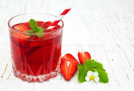 Glass with strawberry drink on a wooden backgroundの写真素材