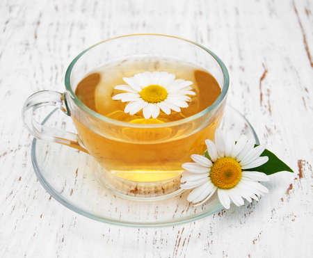 Cup of herbal tea with chamomile on a old wooden backgroundの写真素材