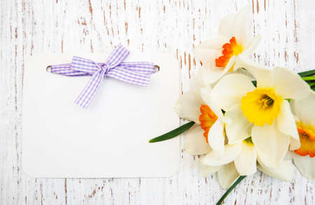 daffodil flowers with card on a wooden backgroundの写真素材