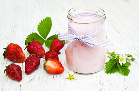 Strawberry yogurt with fresh strawberries on a wooden backgroundの写真素材