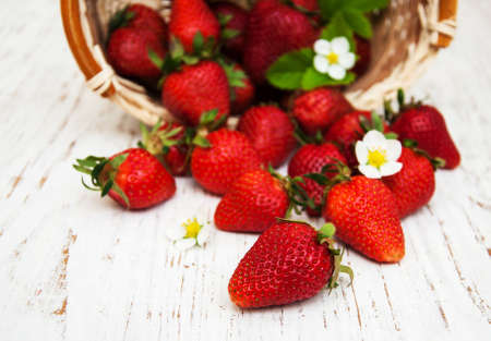 Strawberries with leaves on a wooden backgroundの写真素材