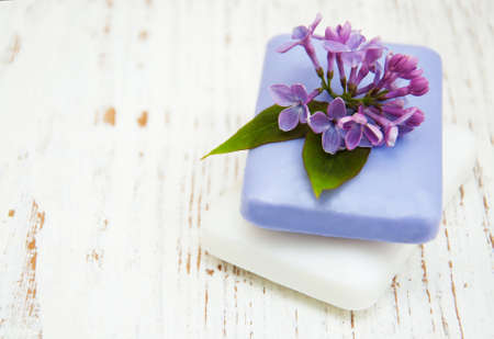 Natural handmade soap and lilac flowers on a wooden backgroundの写真素材