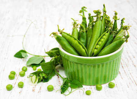 Bowl with fresh peas on a wooden backgroundの写真素材