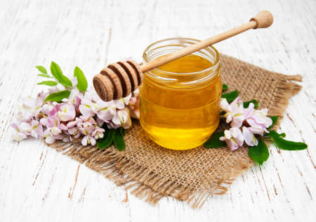 honey with acacia blossoms on a wooden backgroundの写真素材