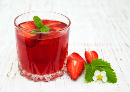Glass with strawberry drink on a wooden backgroundの写真素材