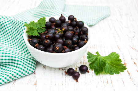 Bowl with black currant on a wooden backgroundの写真素材