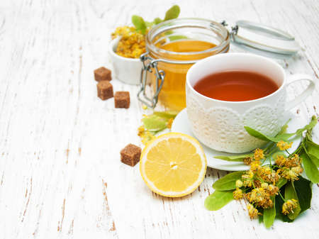 cup of herbal tea with linden flowers on a old wooden backgroundの写真素材