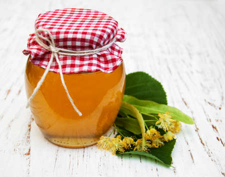 Jar with honey and linden flowers on a wooden backgroundの写真素材